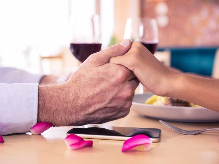 Man holding hands of woman in restaurant