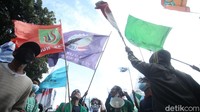 Bendera dari berbagai himpunan buruh dikibarkan para massa aksi.