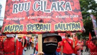 Massa membentangkan sejumlah poster bertuliskan aksi penolakan terhadap Omnibus Law UU Cipta Kerja.