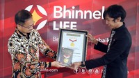 Direktur Utama Bhinneka Life Wiroyo Karsono (kiri) menerima piagam penghargaan pemecahan rekor Museum Rekor Dunia Indonesia (MURI) dari Senior Manager MURI Triyono (kanan) atas rekor Pemberian Polis Asuransi Jiwa di Lokasi Terbanyak senilai total manfaat Rp 160 miliar di Jakarta, Kamis (22/10). Foto: dok. Bhineka Life