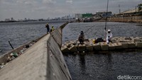 Sejumlah warga memancing di kawasan tanggul laut yang roboh di Pelabuhan Nizam Zachman Muara Baru, Jakarta Utara, Kamis (22/10/2020).  