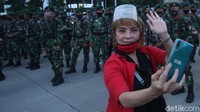 Beberapa massa pun menyempatkan diri untuk berfoto bersama dengan anggota TNI yang bertugas.