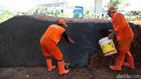Para petugas PPSU tampak menyelesaikan pembangunan trek sepeda di kolong Tol Becakayu tersebut.