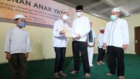 Direktur Pemberdayaan Kawasan Pusat Pengelolaan Komplek (PPK) Kemayoran, Biwodotomo Witoradyo, bersama Kepala Satuan Pengawas Intern PPK Kemayoran, Misbahudin, memberikan santunan kepada perwakilan anak yatim piatu di Masjid Akbar Kemayoran, Jakarta, Jumat (23/10/2020).