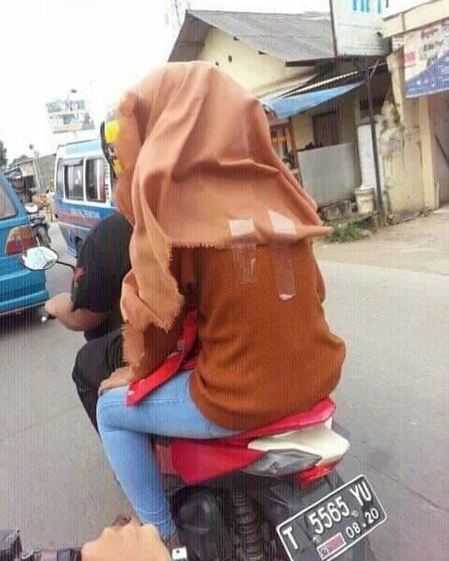 Biar jilbabnya nggak terbang terus mba yang satu ini milih untuk pakai selotip. Padahal bisa pakai helm saja loh mba.. Foto: Instagram/@receh.id