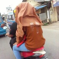Biar jilbabnya nggak terbang terus mba yang satu ini milih untuk pakai selotip. Padahal bisa pakai helm saja loh mba.. Foto: Instagram/@receh.id