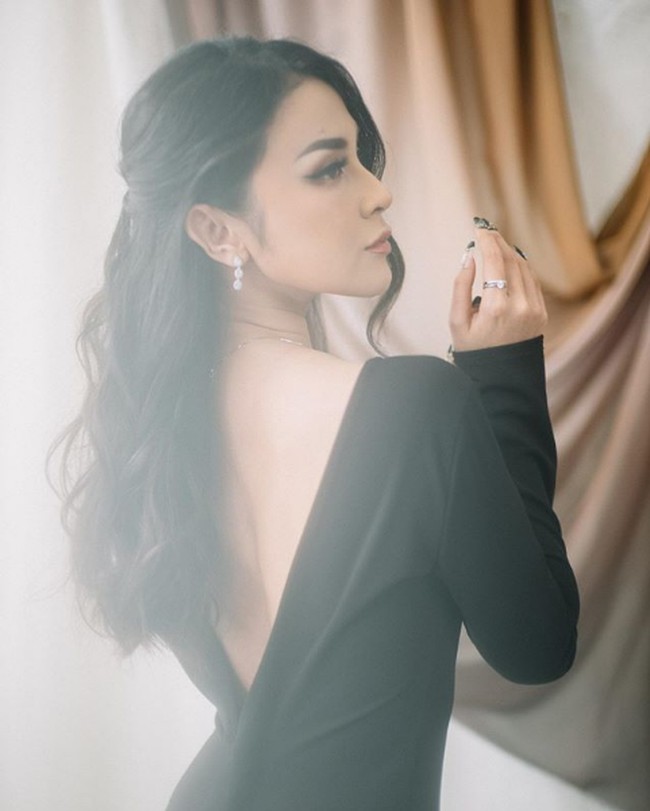 Vicy Melanie cantik bergaun hitam panjang dengan model backless. Rambutnya tampak ditata bergelombang dan dikuncir tengah. Gaun merupakan rancangan desainer Devina Christiani. Foto: Instagram/@vicymelanie
