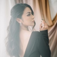 Vicy Melanie cantik bergaun hitam panjang dengan model backless. Rambutnya tampak ditata bergelombang dan dikuncir tengah. Gaun merupakan rancangan desainer Devina Christiani. Foto: Instagram/@vicymelanie