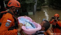 Perlahan anggota Basarnas memindahkan bayi tersebut ke dalam perahu karet.