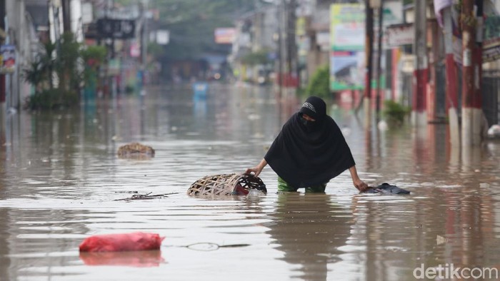 Warga melintasi banjir di Perumahan Pondok Gede Permai, Kota Bekasi, Jawa Barat, Minggu (25/10/2020). Sejumlah wilayah di banjir sejak semalam terendam banjir. Salah satunya banjir berada di Perumahan Pondok Gede Permai pagi ini setinggi 90 cm. Agung Pambudhy/Detikcom.