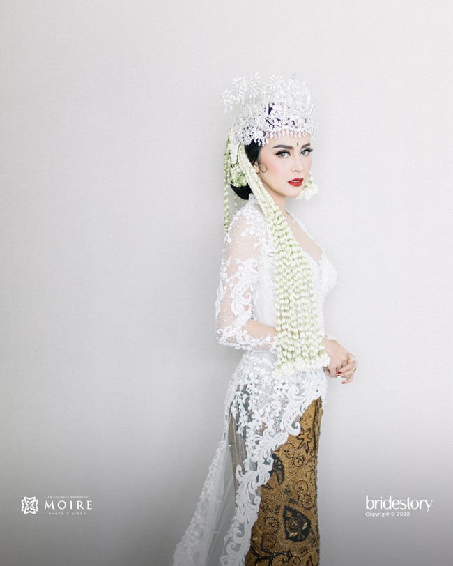 Di momen spesial tersebut, Vicy Melania menjelma sebagai pengantin Sunda. Ia memakai kebaya bernuansa putih dari Kopaka Bridal Couture by Misa. (Foto: Dok. Moire Photo/ Bridestory)