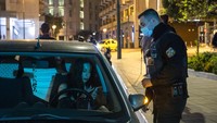 Seorang polisi memeriksa dokumen pengemudi di alun-alun Syntagma, Athena, Yunani.  