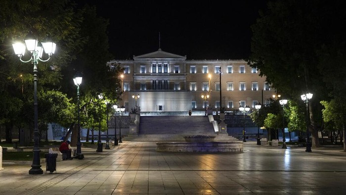Lengangnya Ibu Kota Yunani Saat Jam Malam Police officers wait to check documents of drivers in Athens, Greece, Sunday, Oct. 25, 2020. Greece's government has imposed a nightly curfew in greater Athens and other areas with high infection rates as well as a mask requirement. (AP Photo/Yorgos Karahalis)