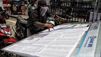 Warga mengecek daftar nama penerima BLT UMKM yang terpampang di depan bank.