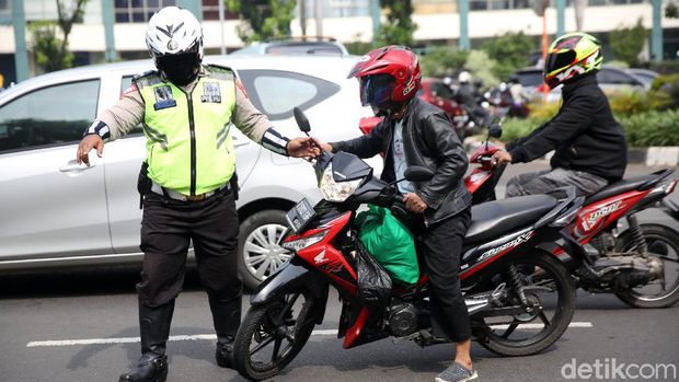 Anggota Polisi Satua Lalu Lintas Polres Jakarta Timur melakukan razia kendaraan bermotor di Jalan DI Panjaitan, Cawang, Jakarta Timur, Senin (26/10/2020). Operasi Zebra 2020 mulai digelar Senin (26/10). Ada lima jenis pelanggaran yang menjadi prioritas sasaran penindakan dalam operasi yang akan berlangsung hingga 8 November mendatang.