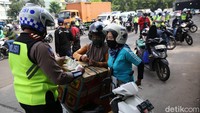 Polisi memeriksa surat-surat kendaraan pengendara yang melanggar lalu lintas.