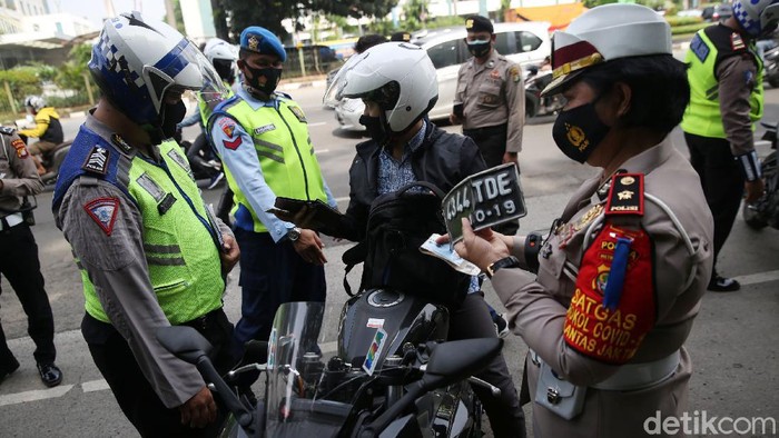 Anggota Polisi Satua Lalu Lintas Polres Jakarta Timur melakukan razia kendaraan bermotor di Jalan DI Panjaitan, Cawang, Jakarta Timur, Senin (26/10/2020). Operasi Zebra 2020 mulai digelar Senin (26/10). Ada lima jenis pelanggaran yang menjadi prioritas sasaran penindakan dalam operasi yang akan berlangsung hingga 8 November mendatang.