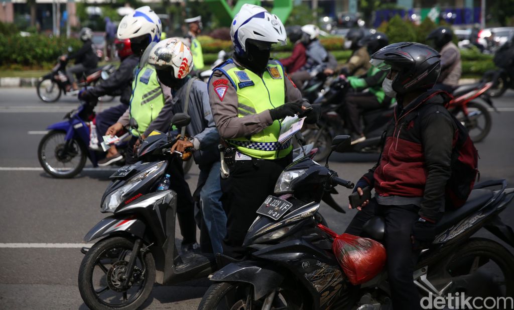 Anggota Polisi Satua Lalu Lintas Polres Jakarta Timur melakukan razia kendaraan bermotor di Jalan DI Panjaitan, Cawang, Jakarta Timur, Senin (26/10/2020). Operasi Zebra 2020 mulai digelar Senin (26/10). Ada lima jenis pelanggaran yang menjadi prioritas sasaran penindakan dalam operasi yang akan berlangsung hingga 8 November mendatang.