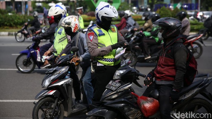 Anggota Polisi Satua Lalu Lintas Polres Jakarta Timur melakukan razia kendaraan bermotor di Jalan DI Panjaitan, Cawang, Jakarta Timur, Senin (26/10/2020). Operasi Zebra 2020 mulai digelar Senin (26/10). Ada lima jenis pelanggaran yang menjadi prioritas sasaran penindakan dalam operasi yang akan berlangsung hingga 8 November mendatang.