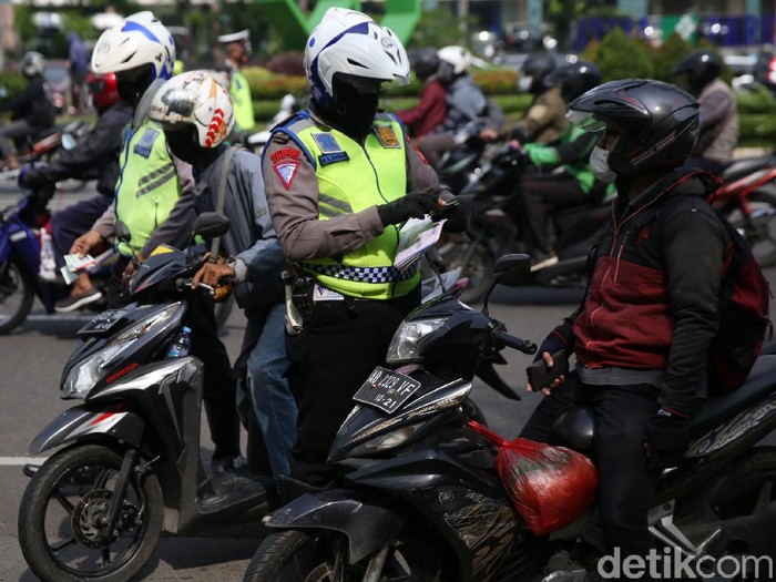 Anggota Polisi Satua Lalu Lintas Polres Jakarta Timur melakukan razia kendaraan bermotor di Jalan DI Panjaitan, Cawang, Jakarta Timur, Senin (26/10/2020). Operasi Zebra 2020 mulai digelar Senin (26/10). Ada lima jenis pelanggaran yang menjadi prioritas sasaran penindakan dalam operasi yang akan berlangsung hingga 8 November mendatang.