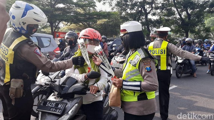 Puluhan polisi dan polwan dari Satlatas Polrestabes Surabaya membagikan bunga dan cokelat kepada pengendara roda dua. Bagi-bagi bunga dan cokelat tersebut sebagai penanda dimulainya Operasi Zebra Semeru 2020.