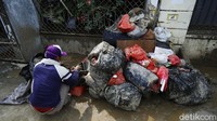 Mereka memilah barang-barang yang dibuang di depan rumah warga.