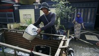 Tukang loak mengumpulkan barang-barang yang telah dibuang oleh pemiliknya. Barang-barang yang dibuang itu sebelumnya sempat terendam banjir.