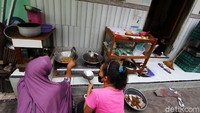 Relawan membuat makan siang di salah satu rumah warga di kampung Gabudan, Pasar Kliwon, Solo. Makan siang itu kemudian diserahkan kepada warga yang dikarantina mandiri.