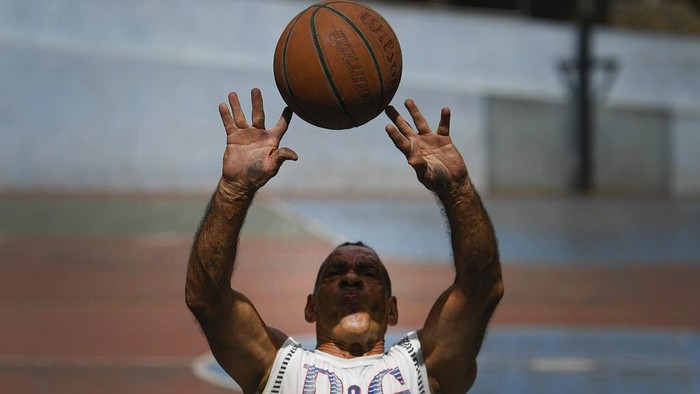 Wheelchair-bound basketball players drive to get to the ball during a game at a public court of the Artigas neighborhood of Caracas, Venezuela, Saturday, Oct. 24, 2020, amid the new coronavirus pandemic. Manuel Mendoza, leader of the Spinal Cord Injury Foundation of Venezuela, organizes wheelchair basketball tournaments in the popular neighborhoods of Caracas. 