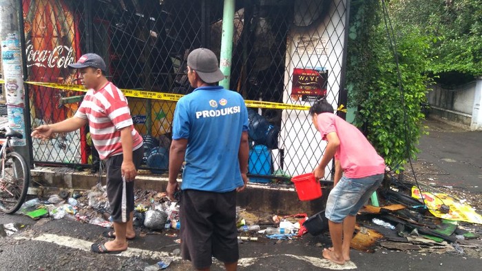 Warga Simprug gotong-royong menyiram sumber kepulan asap dengan alat seadanya