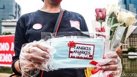 Mereka membawa spanduk, poster serta membagikan masker dan bunga mawar.