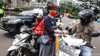 Mereka membagikan bunga kepada para pengendara yang melintas.