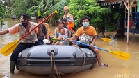 Petugas mengevakuasi korban banjir.