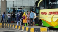 Sejumlah penumpang berkumpul di depan bus yang akan bersiap untuk melakukan perjalanan di Terminal Pulogebang.