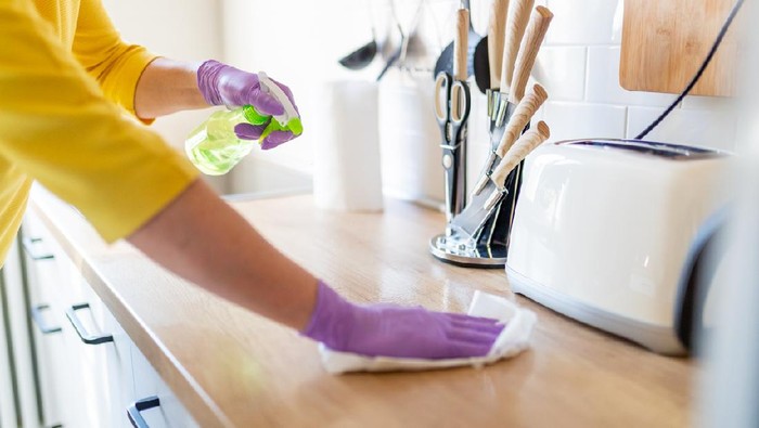 Woman working at home, cleaning the floors, washing the laundry and cleaning up the mess in the closet during quarantine