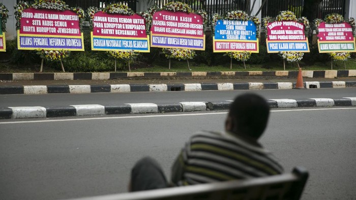 Deretan Karangan Bunga Dukung Penuntasan Kasus Jiwasraya Warga melintas di depan karangan bunga di depan gedung Kejaksaan Agung, Jakarta, Selasa (27/10/2020). Karangan bunga tersebut sebagai bentuk dukungan dan dorongan bagi kejagung untuk mengusut tuntas kasus gagal bayar WanaArtha Life. Dan apresiasi atas penyelesaian kasus PT Asuransi Jiwasraya (Persero) .