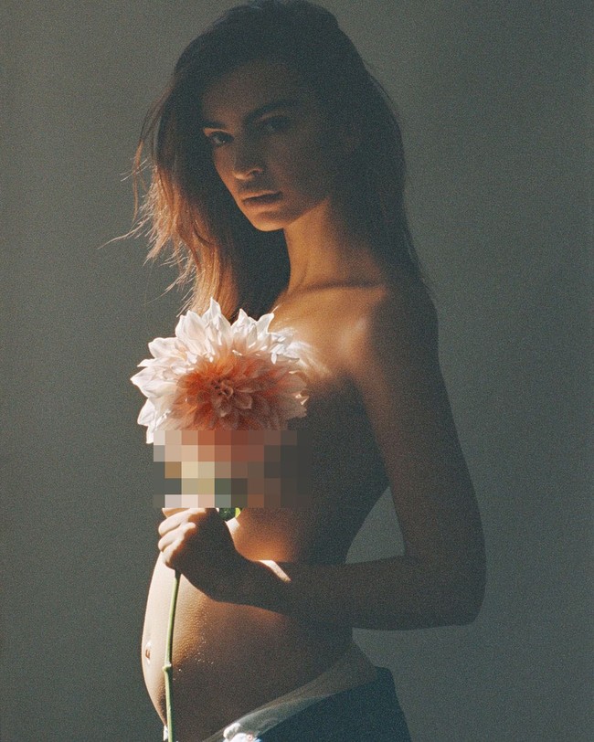 Foto lain menampilkan  Emily Ratajkowski berpose tanpa atasan sehingga memperlihatkan dengan jelas perut buncitnya. Baju untuk menutupi atasan digantinya dengan sebuah bunga. (Foto: Vogue/Cassblackbird)