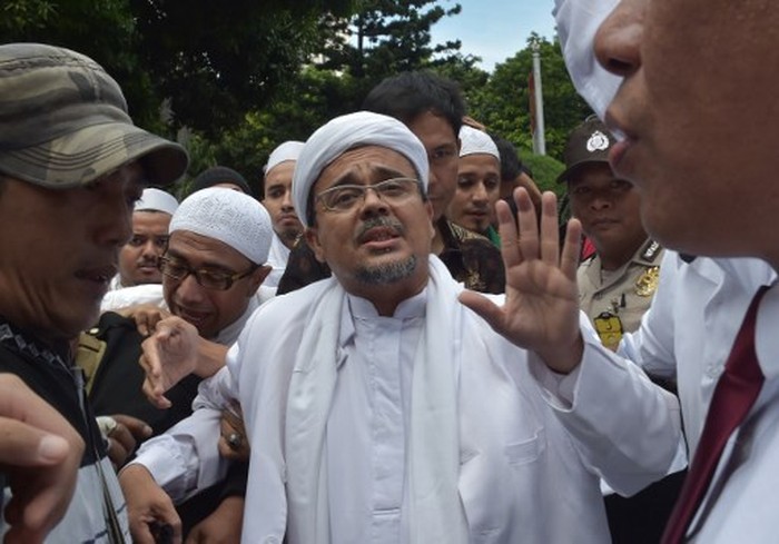 Rizieq Shihab, leader of the Indonesian hardline Muslim group FPI (Front Pembela Islam or Islamic Defender Front), arrives at the police headquarters in Jakarta on January 23, 2017. - Shihab was summoned as a witness by police over allegations he insulted rupiah bank notes by saying they contained communist symbols. (Photo by ADEK BERRY / AFP)