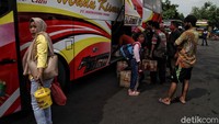 Para penumpang memasukan barang bawaannya ke bagasi bus.