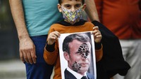 Di mana orang-orang merusak gambar Macron di Suriah. AP Photo/Emrah Gurel  