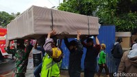 Karyawan dibantu serta warga berusaha menyelamatkan barang-barang yang tersisa.