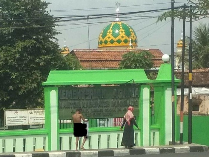 Seorang wanita berikan pakaian kepada pria telanjang di Magelang, Selasa (27/10/2020).