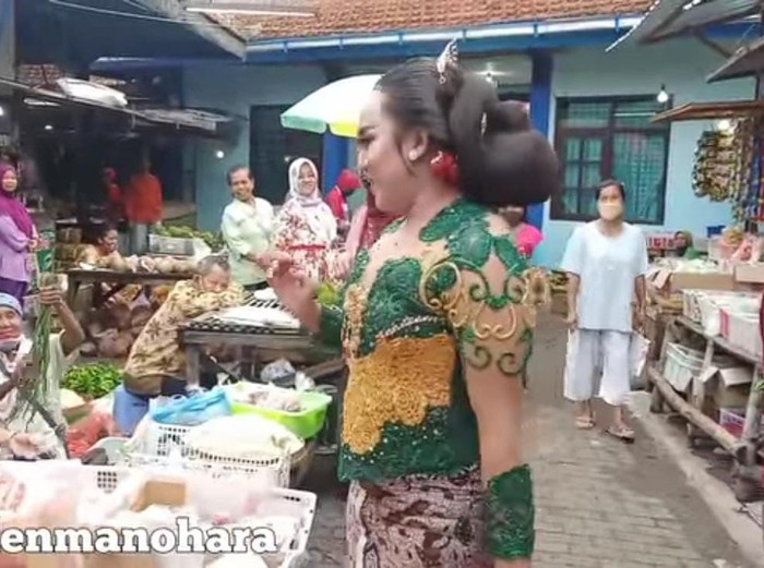 Seorang waria di Madiun punya cara unik untuk menarik perhatian. Ia belanja ke pasar tradisional mengenakan kebaya, sanggul dan make up ala sinden.