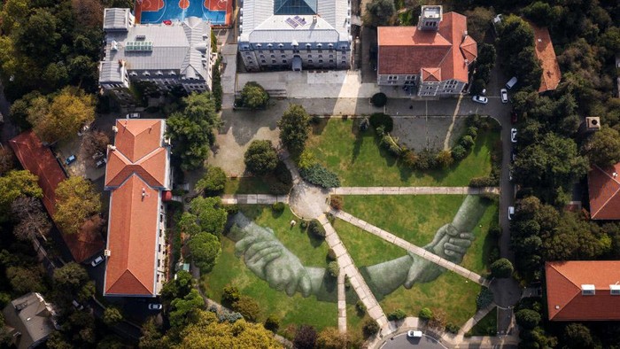Begini Cara Seniman Tunjukkan Solidaritas ISTANBUL, TURKEY - OCTOBER 23: A grass mural created on a floating platform by French land artist Guillaume Legros (Saype) floats in Istanbuls Golden Horn on October 23, 2020 in Istanbul, Turkey. The artwork is part of the artist's 'Beyond Walls Project', launched in 2019 and aims to create the biggest human chain on the planet. The artist's gigantic grass artworks have been completed in many locations around the world and are made using completely biodegradable and eco-friendly airbrush paint that was invented by the artist through research and experimentation. (Photo by Chris McGrath/Getty Images)