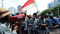 Seorang mahasiswi mencuri perhatian diantara aksi mahasiswa tolak UU Cipta Kerja  di Kawasan Patung Kuda, Jakarta Pusat