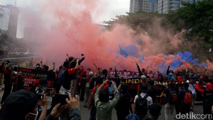 Massa buruh nyalakan smoke bomb di Patung Kuda, Jakarta Pusat