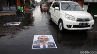 Sejumlah pengendara melintas di jalan yang tertempel poster Emmanuel Macron. Poster itu ditempelkan di jalanan sebagai bentuk protes terhadap Emmanuel Macron.