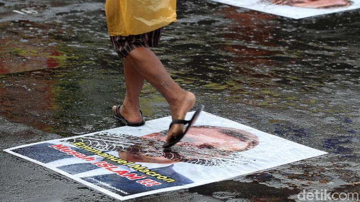 Pengendara melintas di atas poster berwajah presiden Prancis Emmanuel Macron yang ditempel di simpang Jalan Kauman, Yogyakarta, Rabu (28/10/2020). Pemasangan poster bergambar wajah Presiden Prancis tersebut sebagai bentuk protes dan kecaman terhadap pernyataan yang dilontarkan oleh Emmanuel Macron yang dianggap menghina umat muslim.