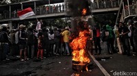 Ban bekas itu dibakar oleh massa di tengah jalan.