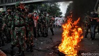 Ban bekas masih terlihat menyala saat TNI menggiring massa remaja meninggalkan Patung Kuda.